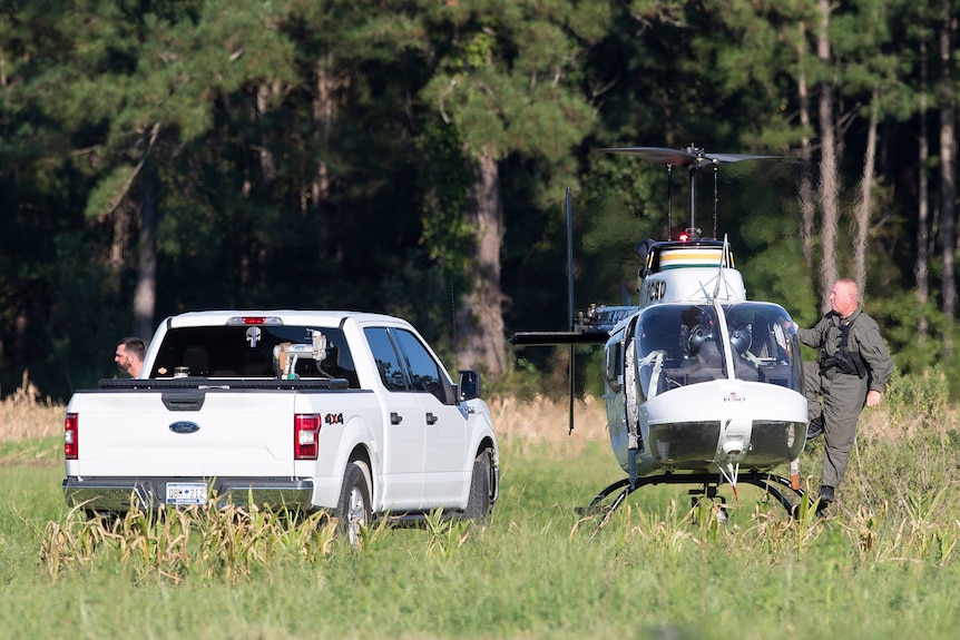 A ute parked next to a helicopter. 