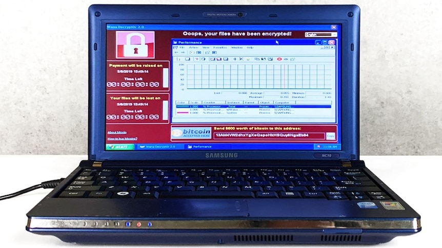 An old laptop is seen with a message on the screen saying, "oops, your files have been encrypted.