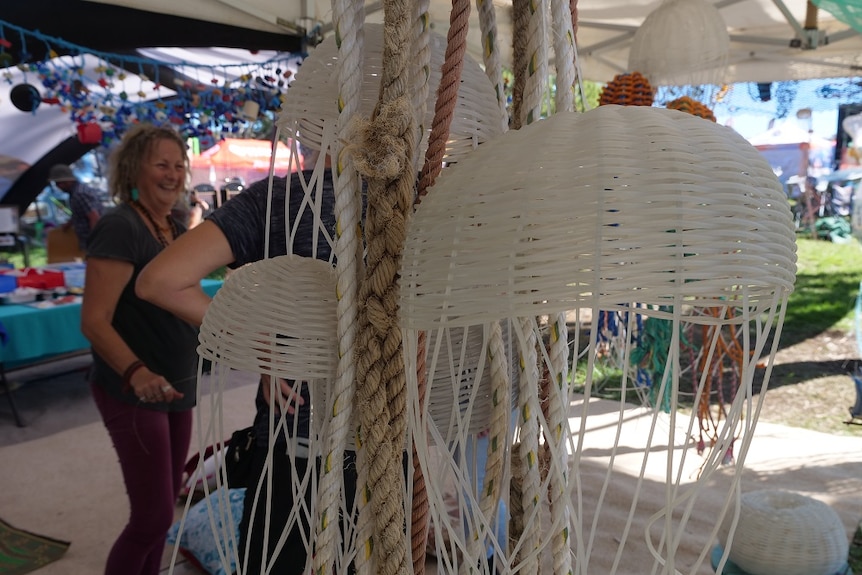 Jellyfish scultptures made from tuna line with people in the background