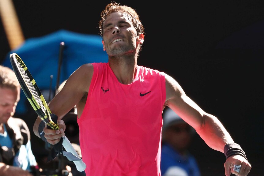 A tennis player closes his eyes and pumps his fist after winning an Australian Open match.