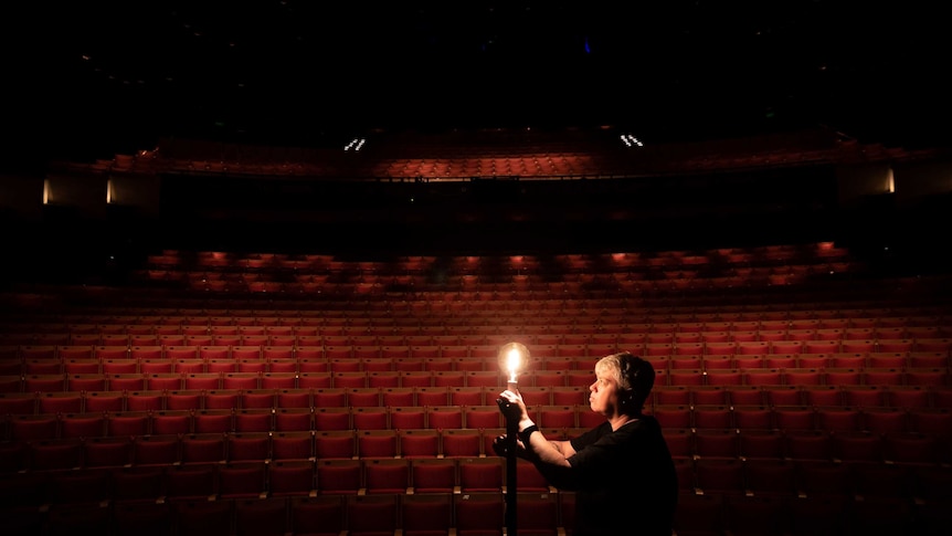 The Sydney Opera House's head of lighting, Ange Sullivan, lights a lone globe in the empty auditorium