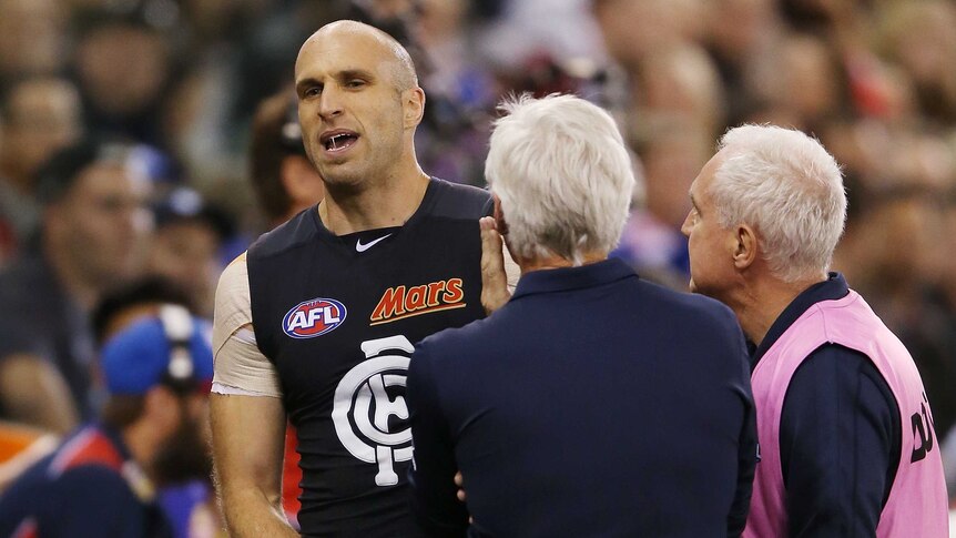 Injury blow ... Chris Judd speaks to Blues coach Michael Malthouse after limping off the ground