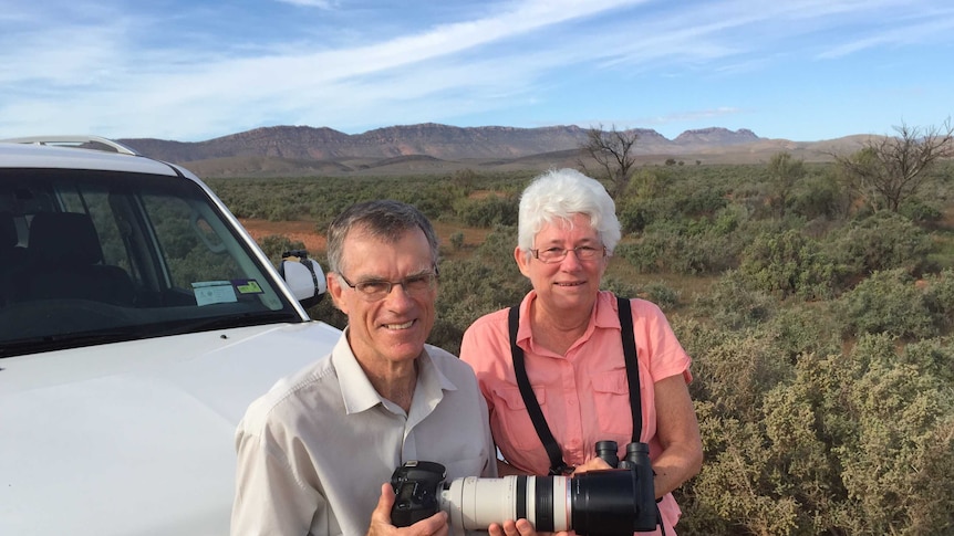 Birdwatchers Jill and John Healy leaning against their car in the Flinders Ranges.