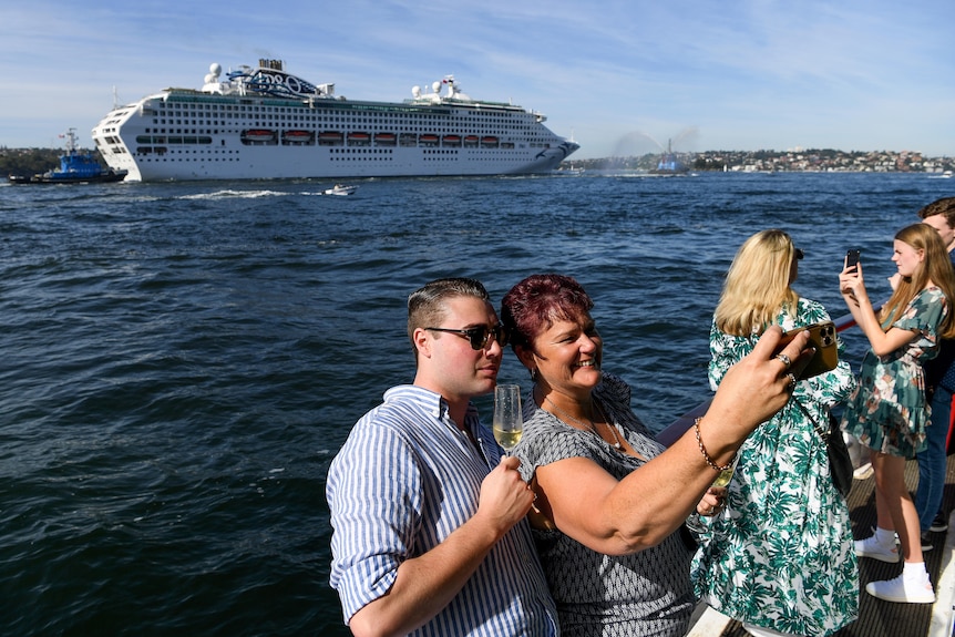 People watch a cruise ship arriving