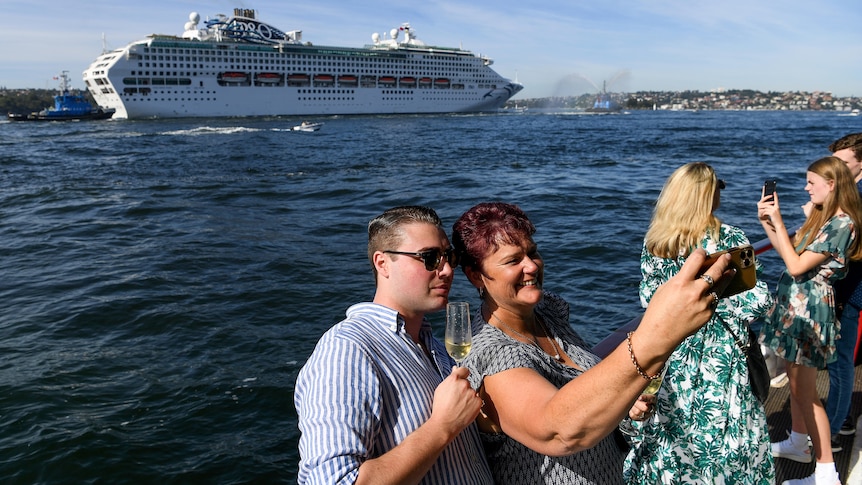 People watch a cruise ship arriving