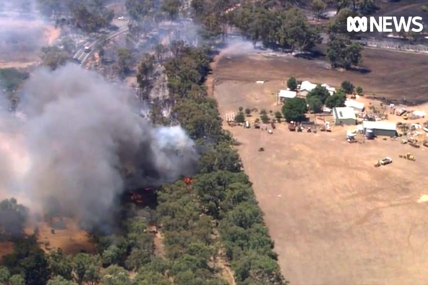 Aerial pic of a bushfire near a collection on buildings.