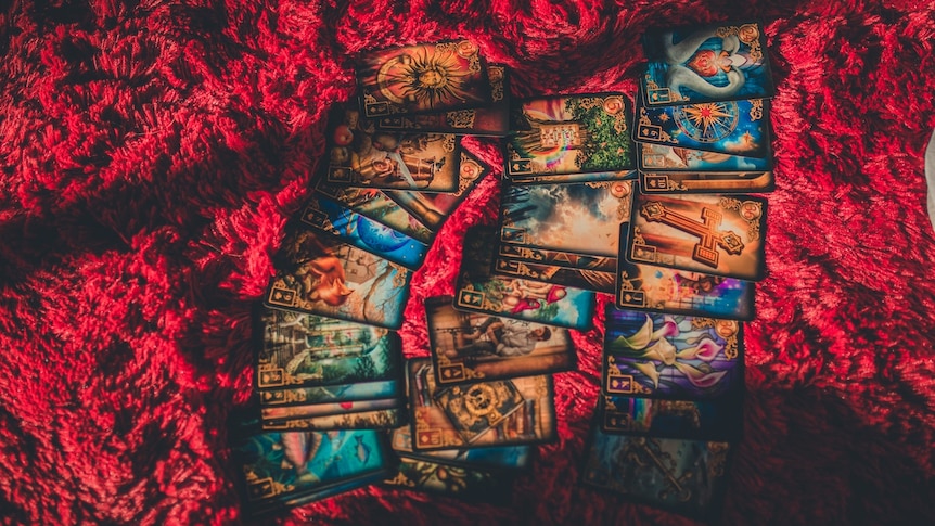 tarot cards laid out on a red capet