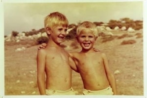 Two children hug in a vintage photograph.