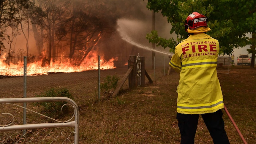 A man sprays flames with a hose.