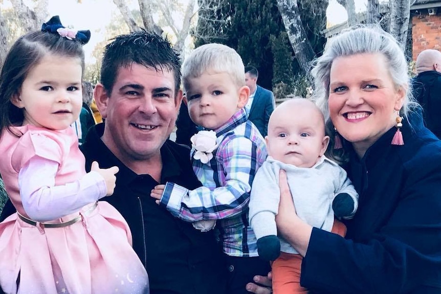 Dean and Kellie-Anne Hancock are pictured with their three children.