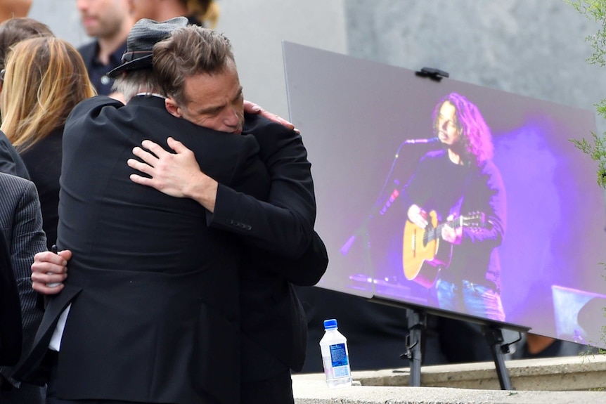 Soundgarden star Matt Cameron hugs a guest at Chris Cornell's funeral.