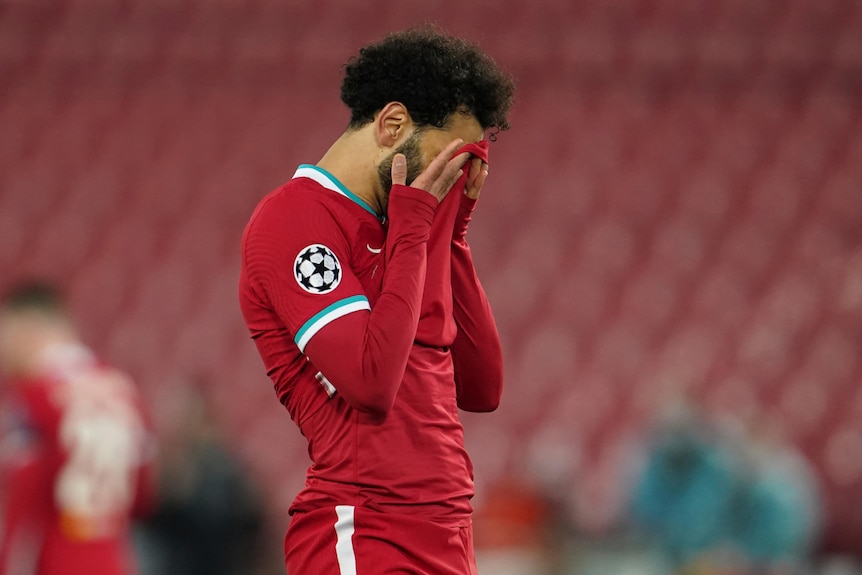 Mo Salah holds his jersey over his face in disappointment