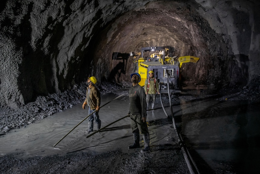 Construction workers inspect a tunnel under construction