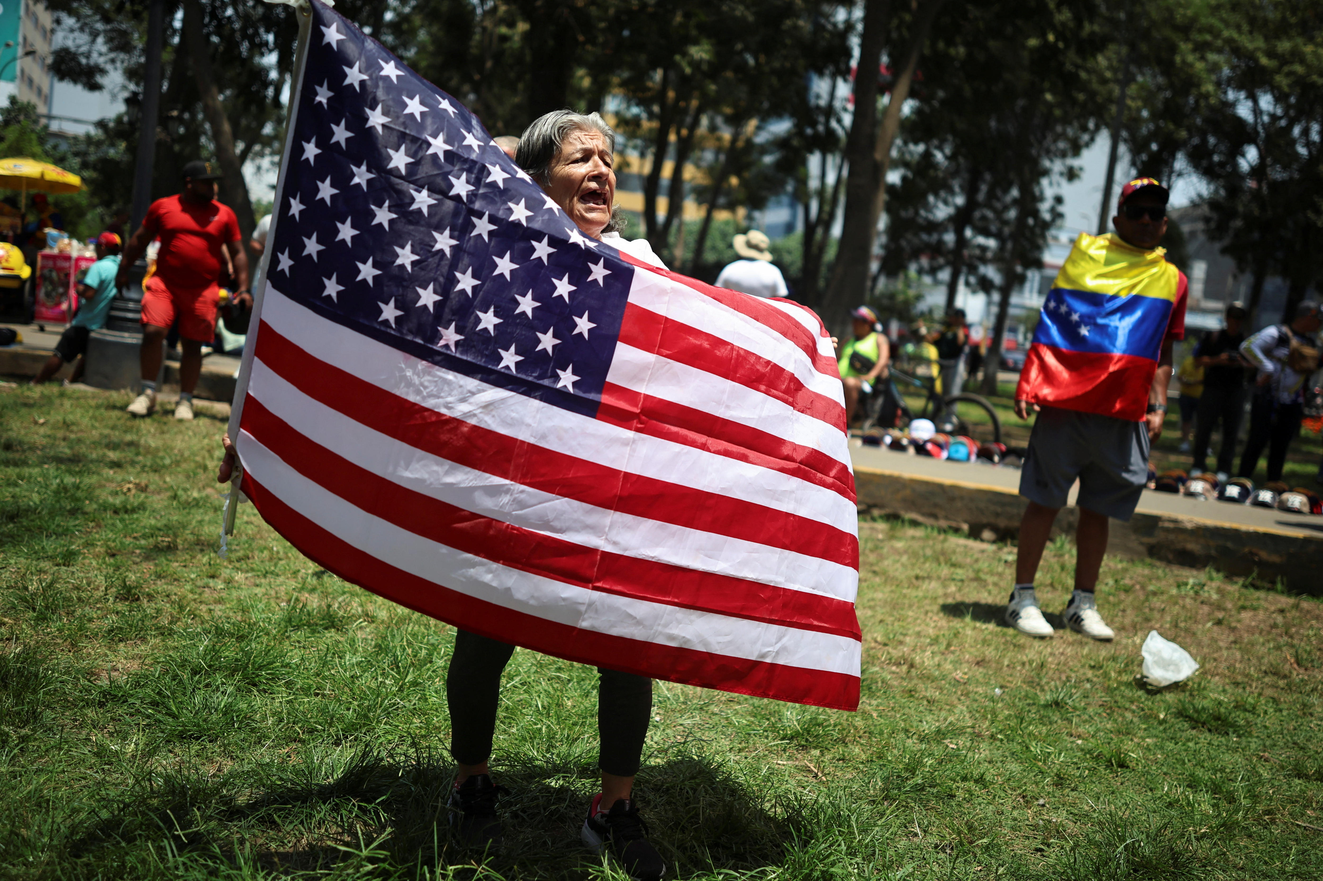 Una mujer sostiene una bandera estadounidense.