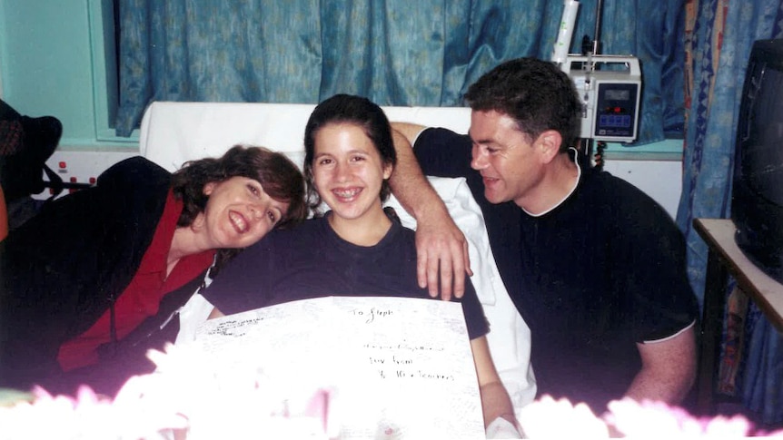 Stephanie Dalzell in a hospital bed, with her mum Anne and her dad John.