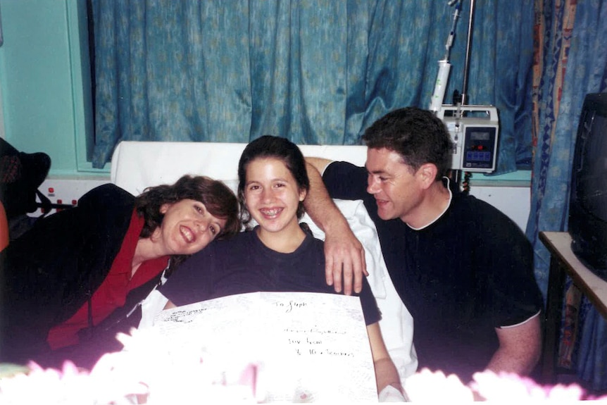 Stephanie Dalzell in a hospital bed, with her mum Anne and her dad John.