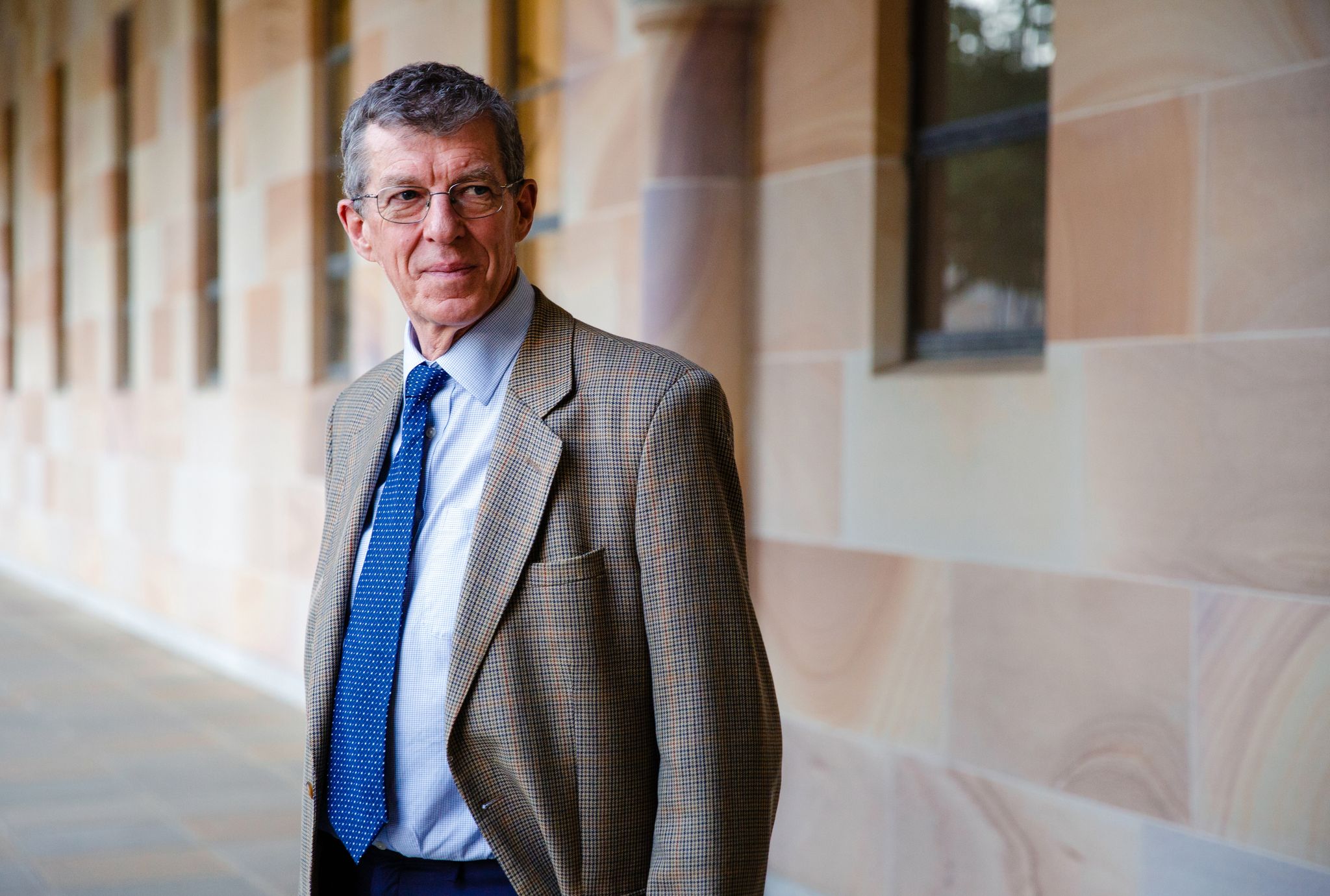 Ian Frazer standing outside a sandstone building. 