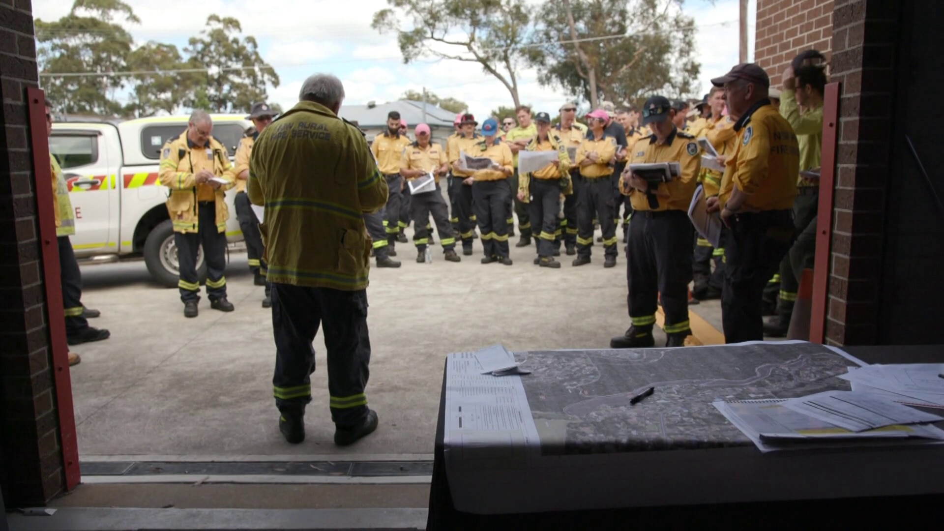 Captain Scott James addresses a group of about two dozen people.