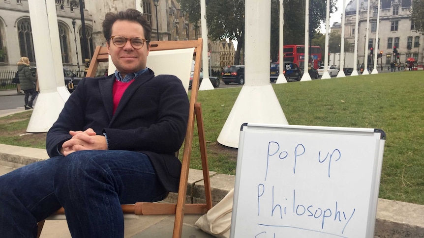 Andre Spicer sitting on a pop up philosophy chair in London