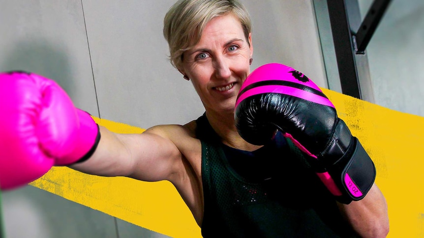 Woman with boxing gloves on throws a punch for a story about boxing benefits, risks and how to start.