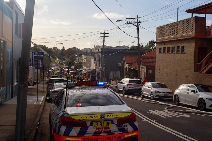 Police cars and emergency services on a street where an e-bike factory caught alight 
