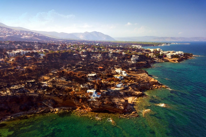 An aerial view of the burnt out town of mati on the coastline of greece.