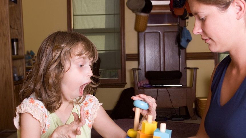 An autistic girl being tested for comprehension with blocks.