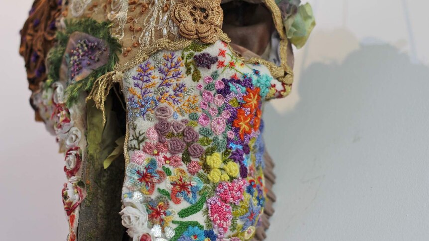 a cow skull decorated with intricate wool embroidery of flowers and lace