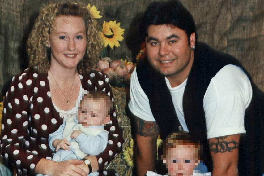 A man woman young girl and baby smile at the camera