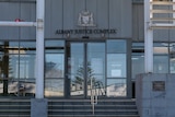 A grey building with the large sign "Albany Justice Complex"