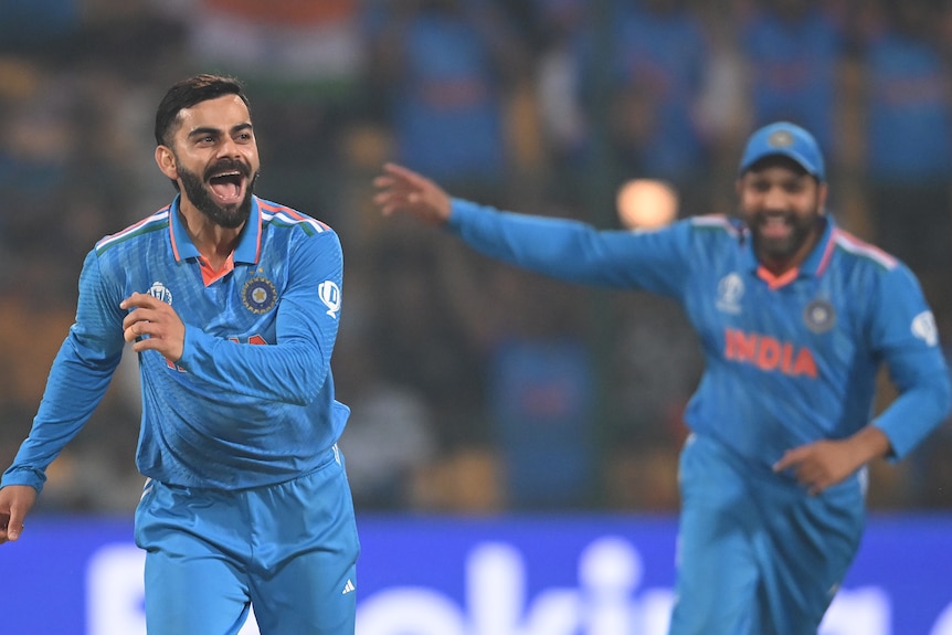 Virat Kohli runs off and smiles after taking a wicket
