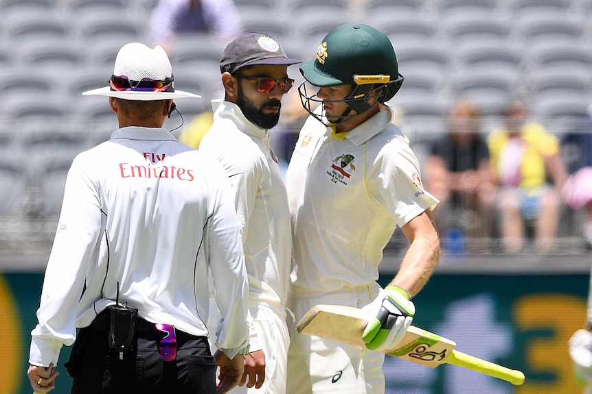 India captain Virat Kohli and Australia captain and batsman Tim Paine touch torsos during a cricket Test.