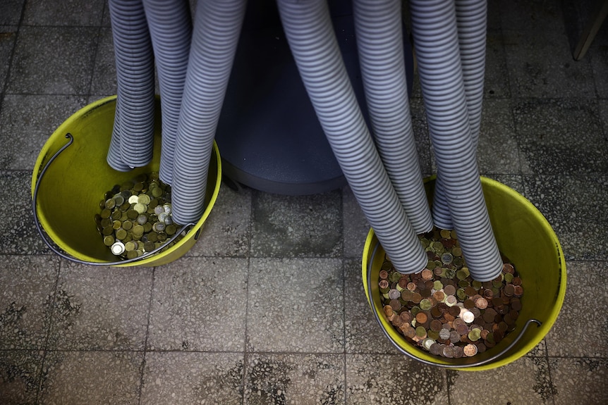 Монеты, собранные в фонтане Треви, попадают в ведро.
