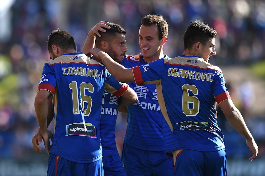 Newcastle Jets players celebrate a goal against Brisbane