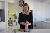 woman in kitchen shredding carrot