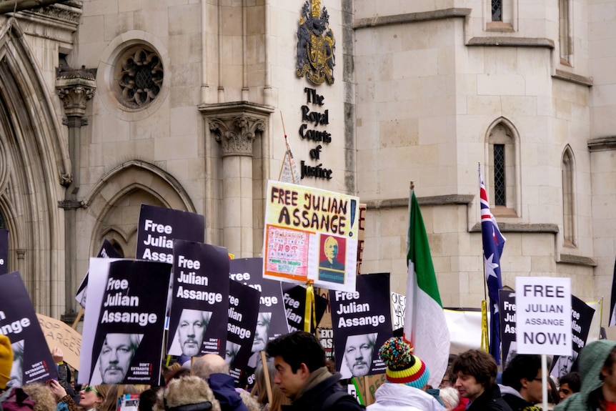 Eine große Menschenmenge hält Schilder mit unterstützenden Parolen für Julian Assange