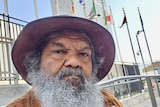 Aboriginal elder with beard and hat in front of the UN Headquarters. 