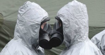 Two people in gas masks face each other in Salisbury