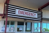A sign that says emergency on a single storey building