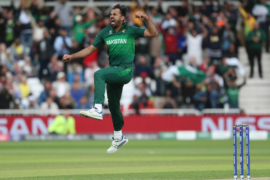 Pakistan cricketer Wahab Riaz jumps to punch the air after taking a wicket.