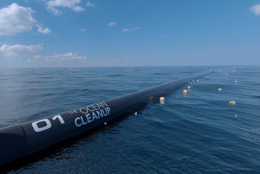 A long plastic pipe floats on the ocean.