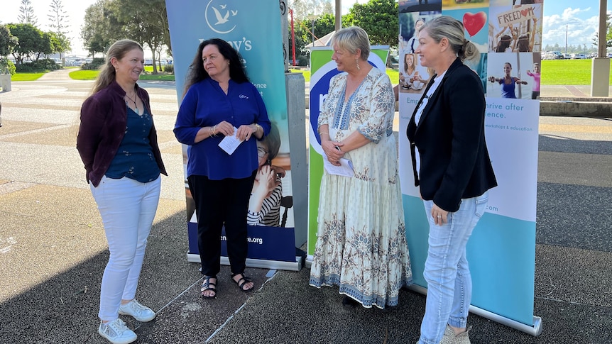 Group of women addressing media in a park.