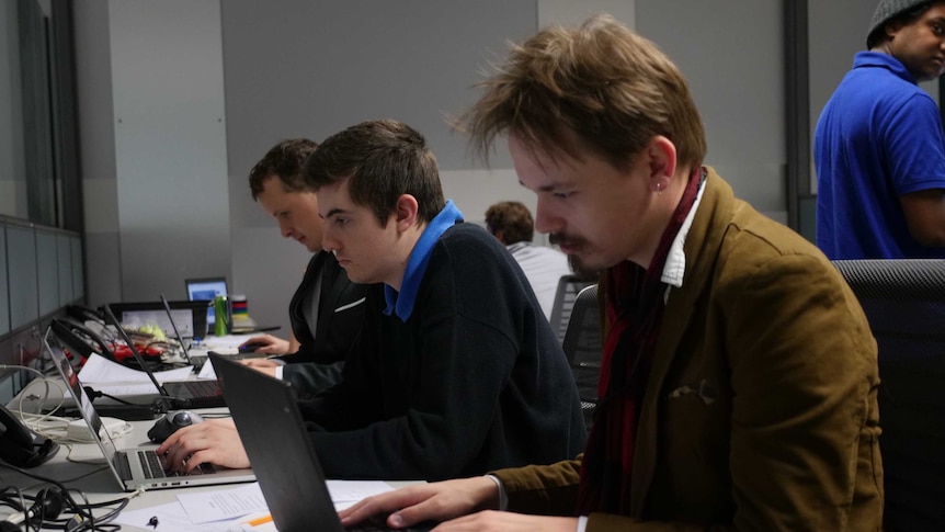 Three men working away at their computers.