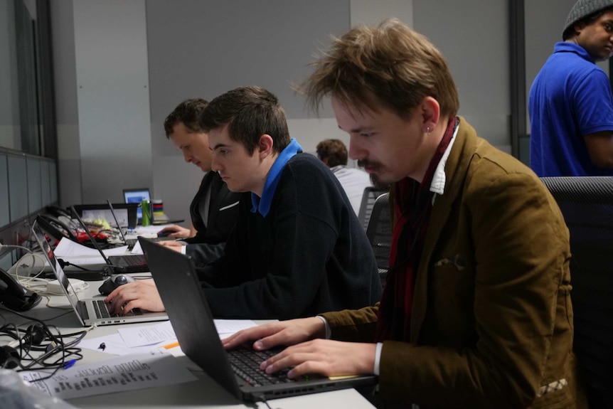 Three men working away at their computers.
