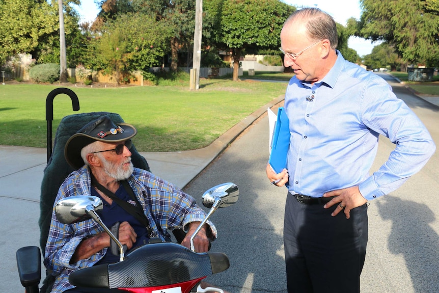 Steve Irons talking to a man in a gofer in the street