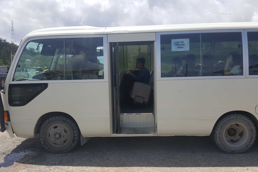 People aboard a white mini van on Manus Island.