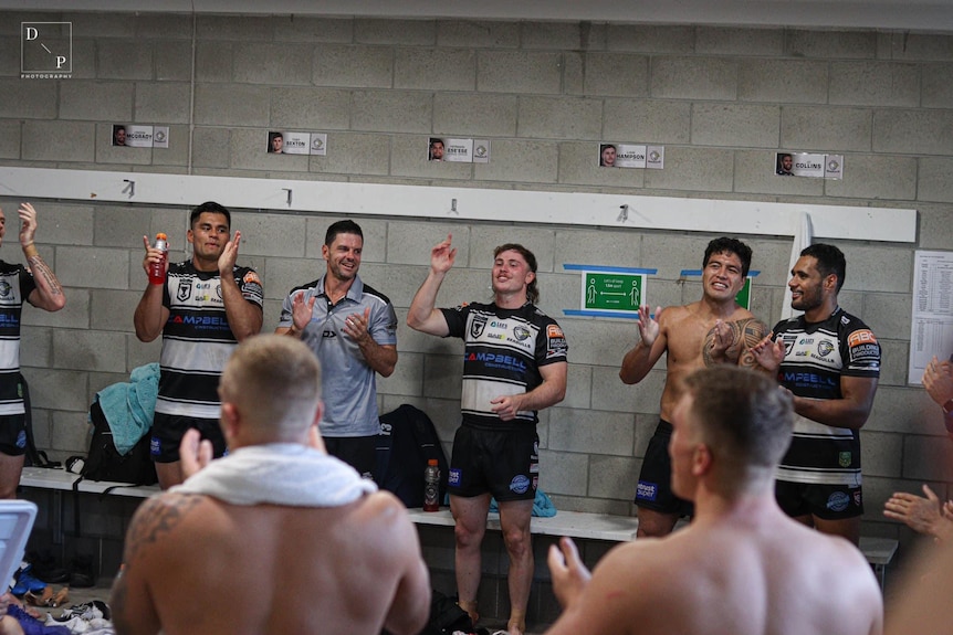 Redcliffe Dolphin Liam Hampson with team mates in a locker room singing.