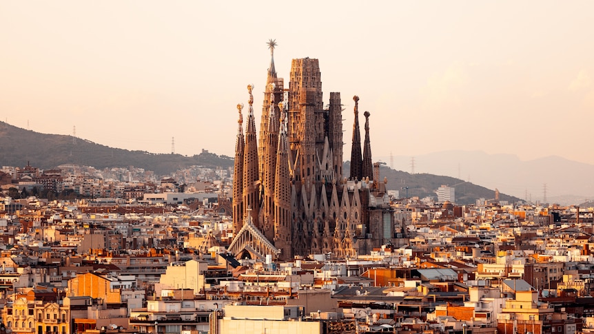 La Sagrada Familia in Barcelona can be seen above buildings in the middle of the city