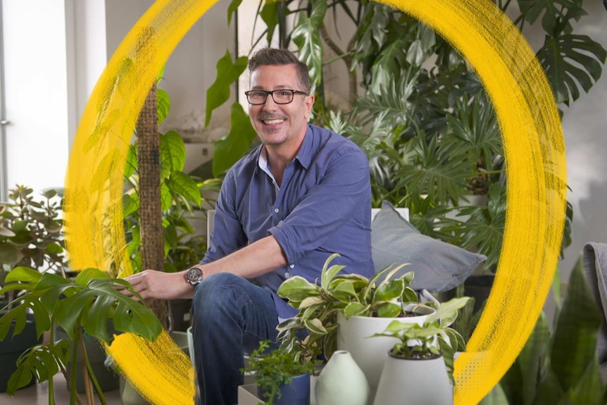 A man sits among his indoor plant collection in Melbourne, teaching how to treat common problems.