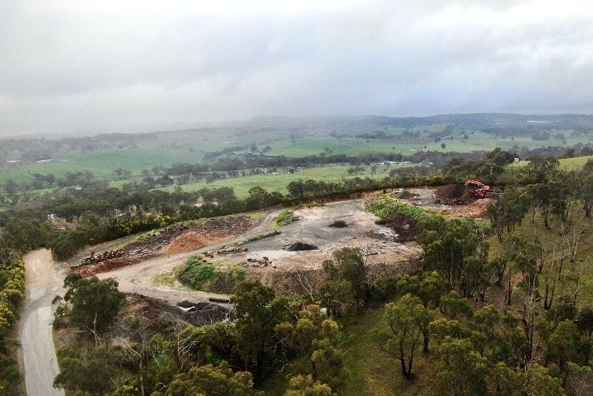 An aerial image of a worksite among a clearing between trees